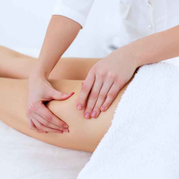 Une femme recevant un massage du bas du dos pour soulager les tensions musculaires.